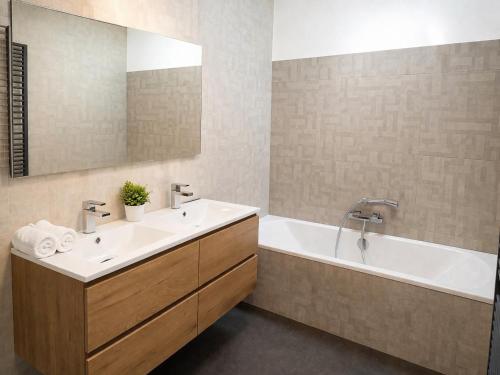 a bathroom with a sink and a tub and a mirror at La Vie En Rose in Muno