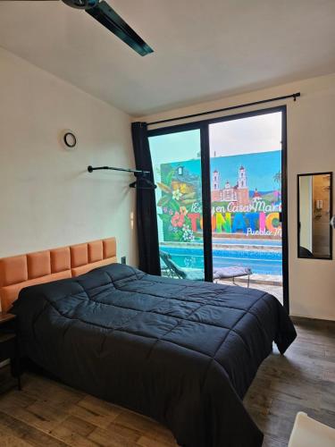a bedroom with a bed and a large window at Casa María in Tonatico