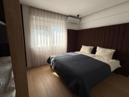 a bedroom with a bed and a window at Bright Apartment with Balcony near Bus and Train in Mostar