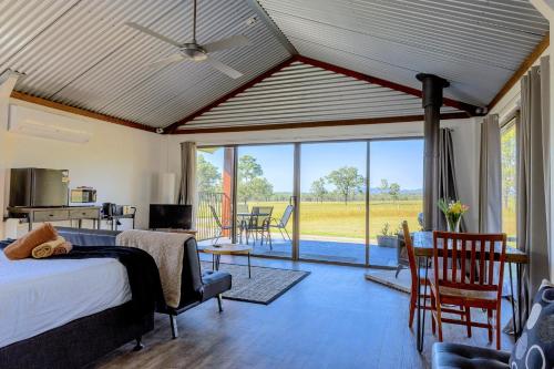 a bedroom with a bed and a living room at Wallaby Lodges in Pokolbin