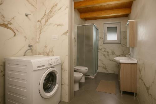 a bathroom with a washing machine and a toilet at Resort Helenia in Caulonia