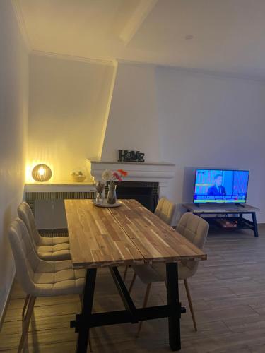 a living room with a wooden table and a television at Bela Vita, Porto Covo in Porto Covo