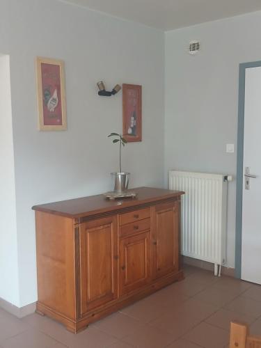 a wooden cabinet with a plant on top of it at L'auberge du Houx in La Houssière