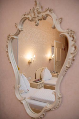 a mirror on a wall with two beds in a room at Pertschy Palais Hotel in Vienna