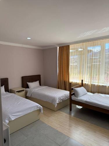 a hotel room with two beds and a window at Vibe Hotel Vanadzor in Vanadzor