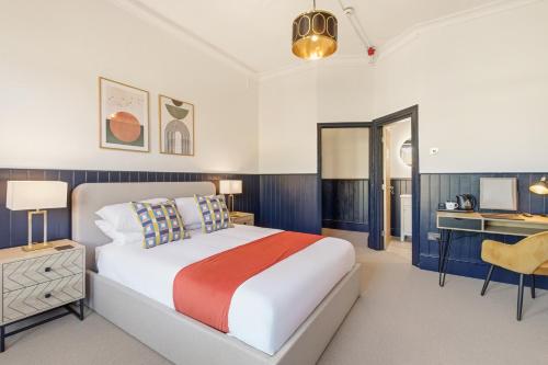 a bedroom with a large bed and a desk at The Jam Jar, Newcastle, Jesmond in High Heaton