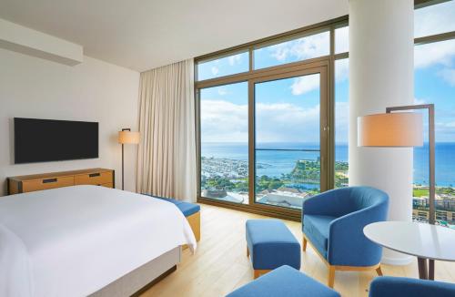 a hotel room with a bed and a view of the ocean at Renaissance Honolulu Hotel & Spa in Honolulu