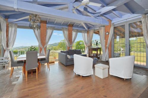 a living room with a table and white chairs at Villa Borgiano - Happy Rentals in Scansano