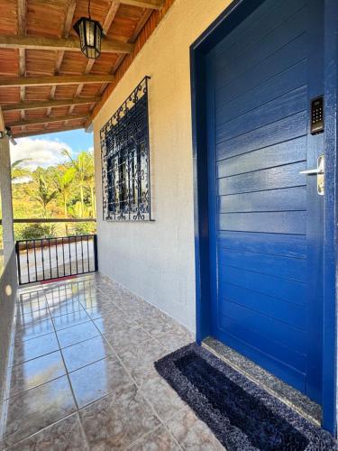 a blue door of a house with a porch at Refúgio Boa Vista in Venda Nova do Imigrante