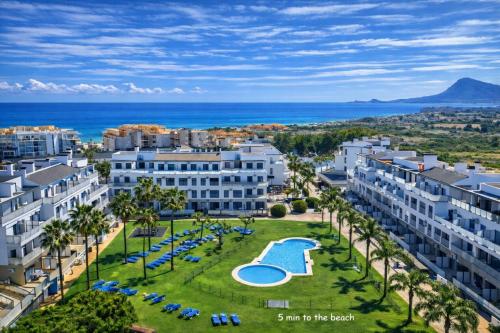 an aerial view of a resort with a pool and palm trees at Sunrise House Oliva Nova Beach & MET Apartment in Oliva
