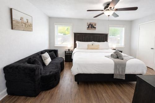 a bedroom with a bed and a chair and a couch at Stylish Villa-Near Stadiums, Large Pool,Pool Table in Bedford