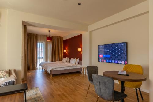 a hotel room with a bed and a table at Habitat Suites II in Craiova