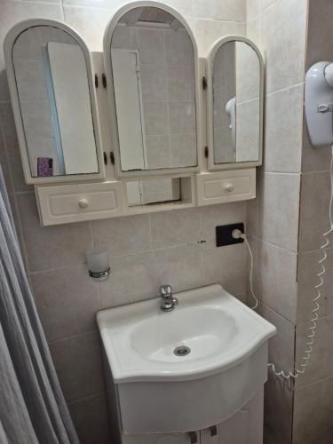 a bathroom with a white sink and two mirrors at Colorina Bariloche en edificio Bariloche Center in San Carlos de Bariloche