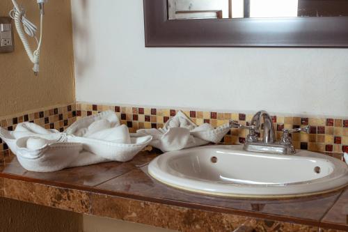 a bathroom sink with towels on a counter at Hotel El Zaguán Histórico in San Cristóbal de Las Casas
