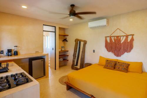 a bedroom with a yellow bed and a stove at Casa Omero Seaview. in El Cuyo