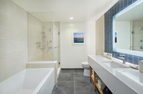 a bathroom with a tub and a sink and a shower at Renaissance Honolulu Hotel & Spa in Honolulu
