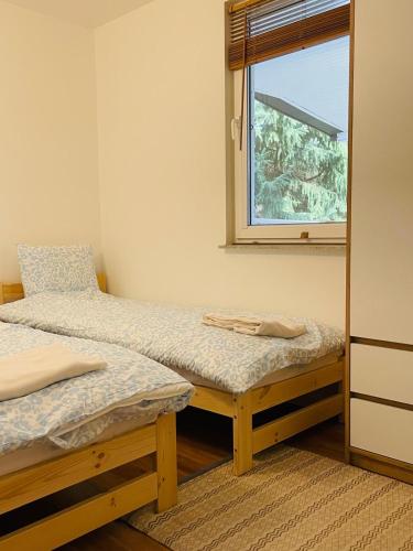 a bedroom with two twin beds and a window at Oaza Jeziorak in Siemiany