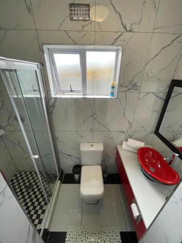 a bathroom with a toilet and a sink and a window at Bluenova guesthouse in Dundee