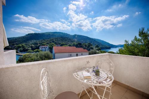 a table and chairs on a balcony with a view at Apartments Bruna in Lastovo