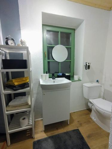 a bathroom with a sink and a mirror and a toilet at Mera Small House in Mera