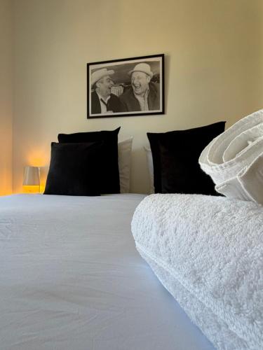 a bedroom with a white bed and a picture of two men at La suite du parc 2 in Nancy