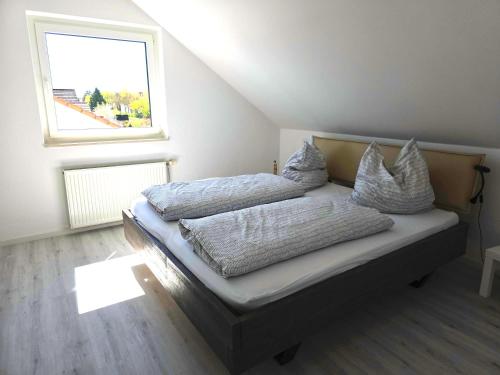 a bedroom with a bed with pillows and a window at Ferienwohnung Groß-Umstadt in Groß-Umstadt