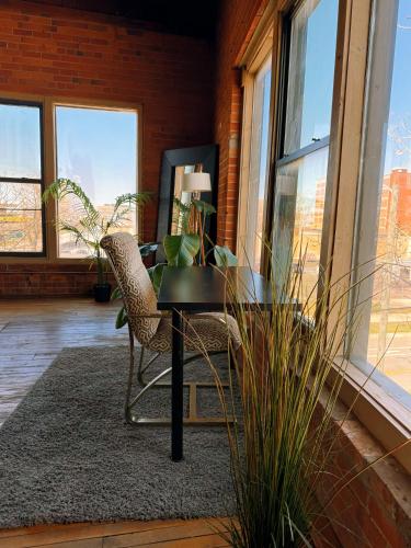 a table and chairs in a room with windows at 420 Friendly SKYLINE view Downtown Loft FREE Parking in Detroit