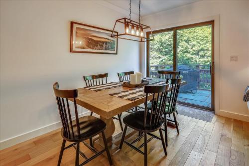 a dining room with a wooden table and chairs at Topnotch Retreat in Stowe Fork