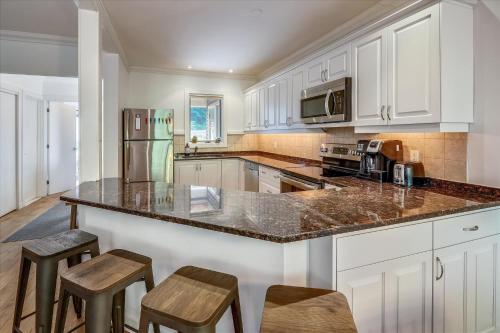 a kitchen with white cabinets and a granite counter top at Topnotch Retreat in Stowe Fork