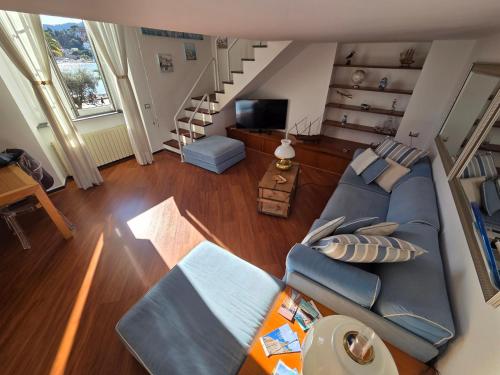 a living room with a blue couch and a staircase at Acquamarina in Rapallo