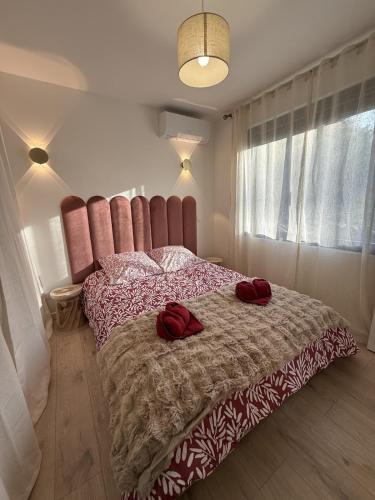 a bedroom with a bed with red pillows on it at Le Refuge Douillet à 10min de Disneyland avec Parking Privé et Belle terrasse vue sur Jardin in Coupvray