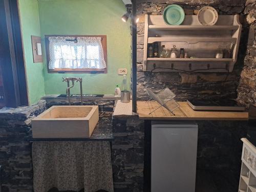 a kitchen with a sink and a stone wall at La Casetta di Molly tra ulivi e roseto in Leivi