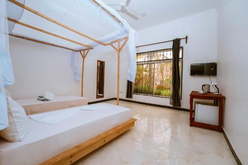 a bedroom with two beds and a window at Farashuu Luna Hotel in Kendwa