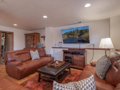 a living room with leather furniture and a flat screen tv at Runnymeade Cottage in Kings Beach