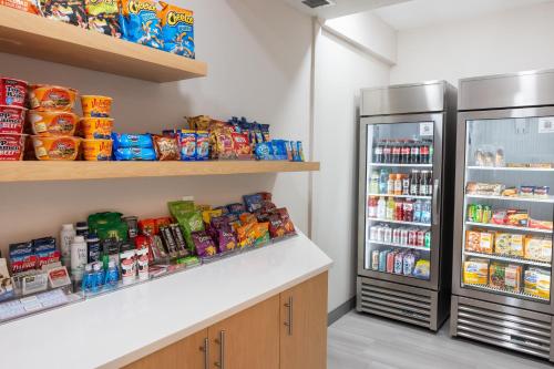 a kitchen with a refrigerator and lots of food at Holiday Inn Express Hotel & Suites Wichita Airport by IHG in Wichita