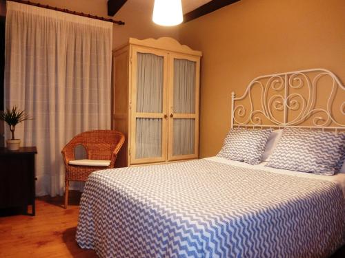 a bedroom with a bed with a blue and white blanket at Casa Cotiellu in Llanes