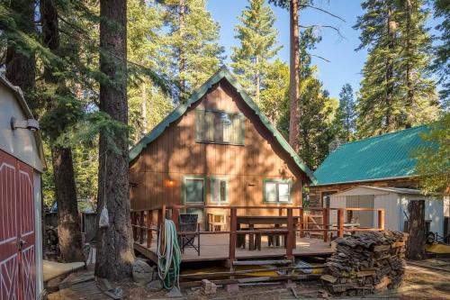 a log cabin in the woods with a large deck at Mirthwood Den in Tahoma