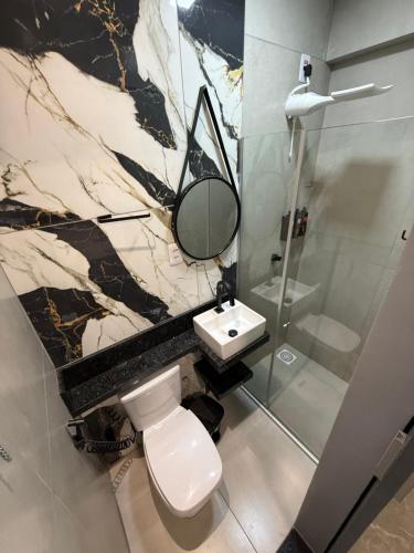 a bathroom with a toilet and a sink and a mirror at 2367 Belém Residence in Belém