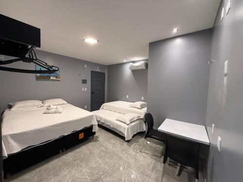 a bedroom with two beds and a desk in it at 2367 Belém Residence in Belém