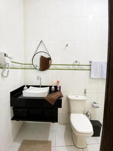 a white bathroom with a sink and a toilet at Casa completa, aconchegante com ar condicionado in Montes Claros