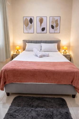 a bedroom with a large bed with three pictures on the wall at Casa completa, aconchegante com ar condicionado in Montes Claros