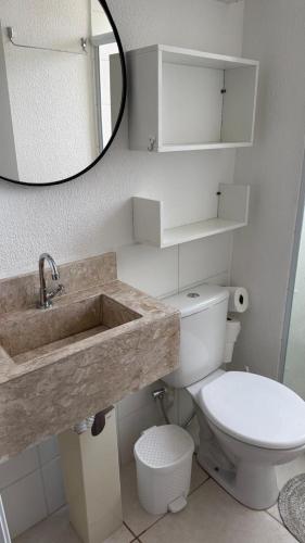 a bathroom with a sink and a toilet and a mirror at Lazer na linha verde in Camaçari