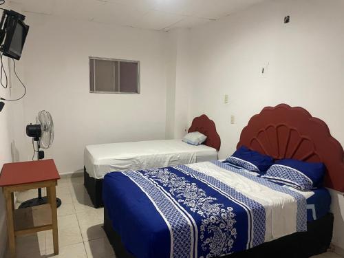 two beds in a room with a tv and a bedskirtspectspectspectspects at Hotel Quinta Don Juan in Tapachula