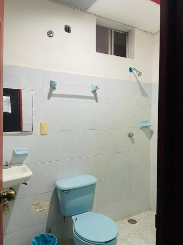 a bathroom with a blue toilet and a sink at Hotel Quinta Don Juan in Tapachula