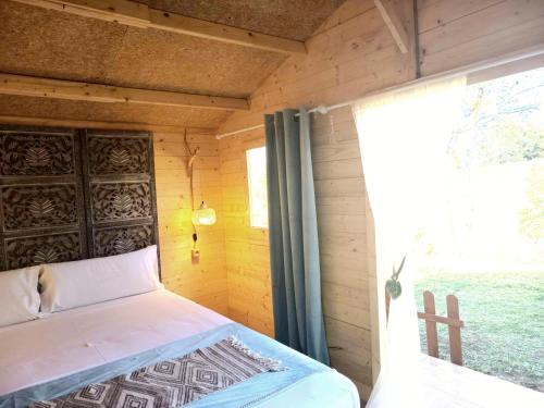 a bedroom with a bed in a room with a window at Casa Bakara in Vejer de la Frontera