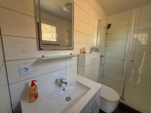 a white bathroom with a sink and a shower at Sonnenblick in Edertal