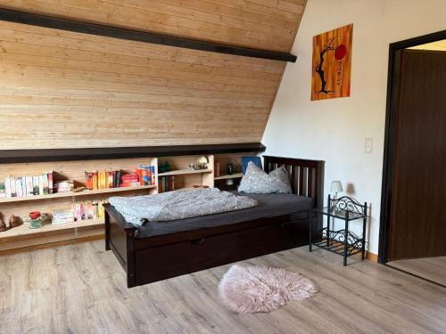 a bedroom with a bed and a book shelf at Sonnenblick in Edertal