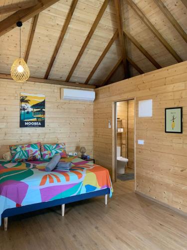 a bedroom with a bed in a room with wooden walls at Fare Teimana Vaianae in Vaianae