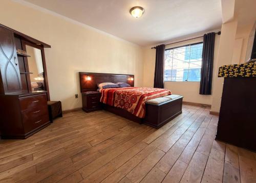 a bedroom with a bed and a dresser and a window at Central Stay Departamentos I - Camacho in Oruro