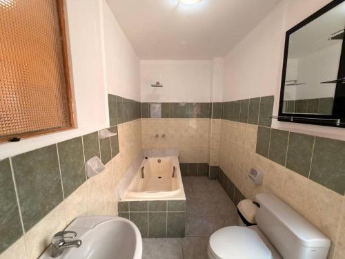 a bathroom with a tub and a sink and a toilet at Central Stay Departamentos I - Camacho in Oruro